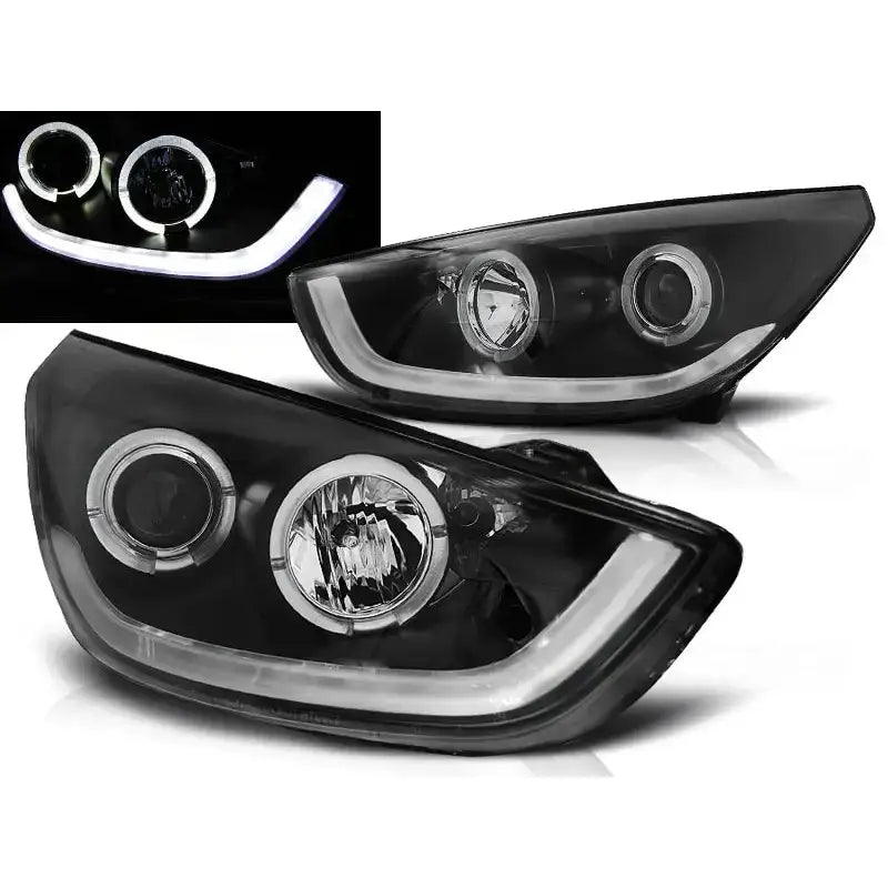 Frontlykter Hyundai Tucson IX35 10-13 med svarte hus, LED-ringer og hvite LED-lys, nærbilde skrått forfra.