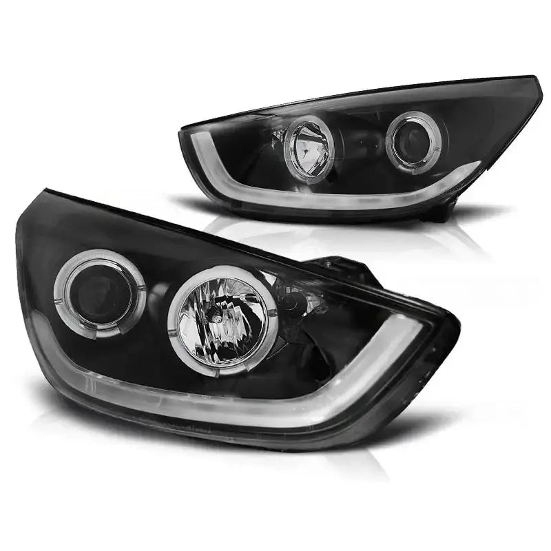 Hovedlykter Hyundai Tucson IX35 10-13 i svart med klare glass og LED-lyslist, sett fra skrå vinkel.