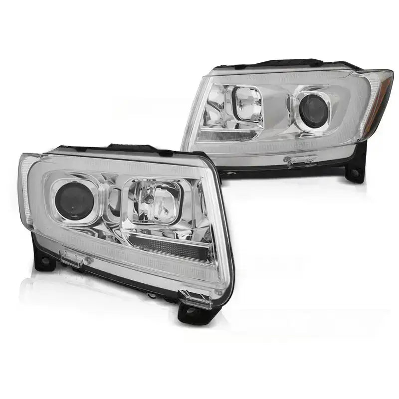 Frontlykter Jeep Grand Cherokee 11-13 med krom tube light, sett skrått forfra, sølvdetaljer og sorte kanter.