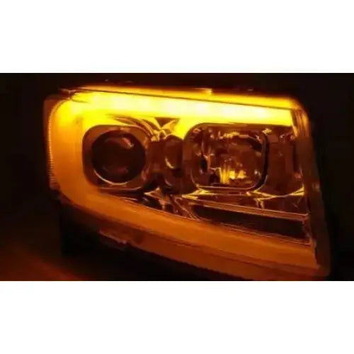 Hovedlys Jeep Grand Cherokee 11-13 Chrome Tube Light SEQ sett med tent gult lys og moderne reflektordesign.