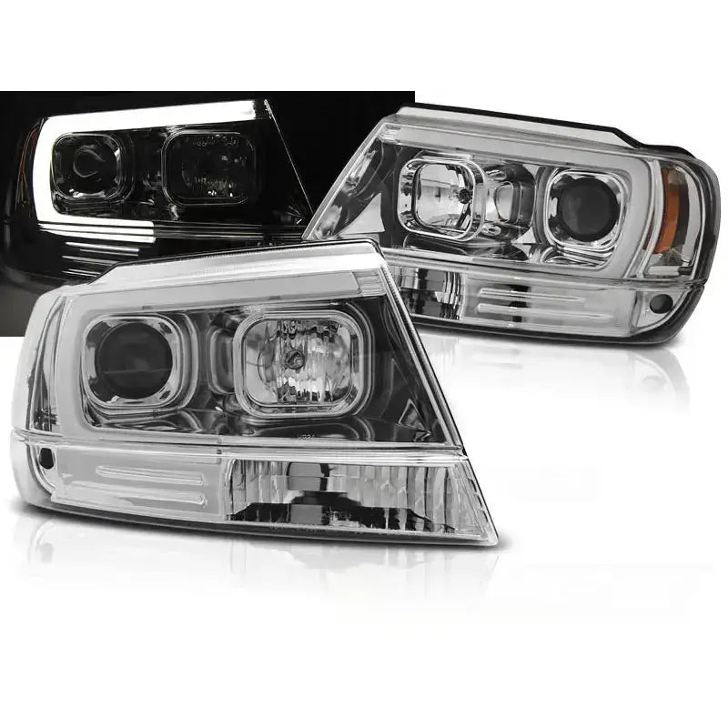 Frontlykter Jeep Grand Cherokee 99-05 Tube Light Chrome med LED-lys og kromdetaljer, sett fra skrå vinkel.