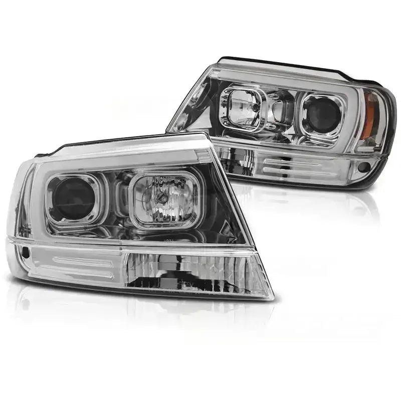 Hovedlykter Jeep Grand Cherokee 99-05.05 med kromdetaljer, rektangulært design, sett fra skrå vinkel.