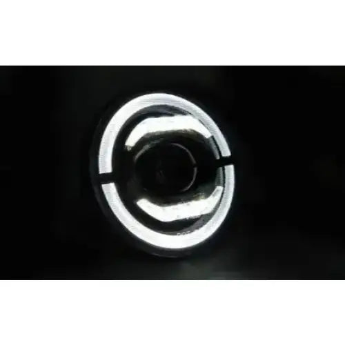 Hovedlykter Jeep Wrangler LED rund modell med buede lyssoner sett forfra mot svart bakgrunn.