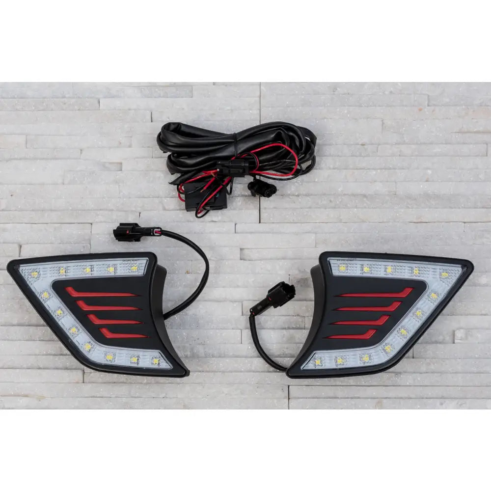 Frontlykter LED til Toyota Hilux 12-15 med røde detaljer og kabler, sett ovenfra på steinmønstret bakgrunn.