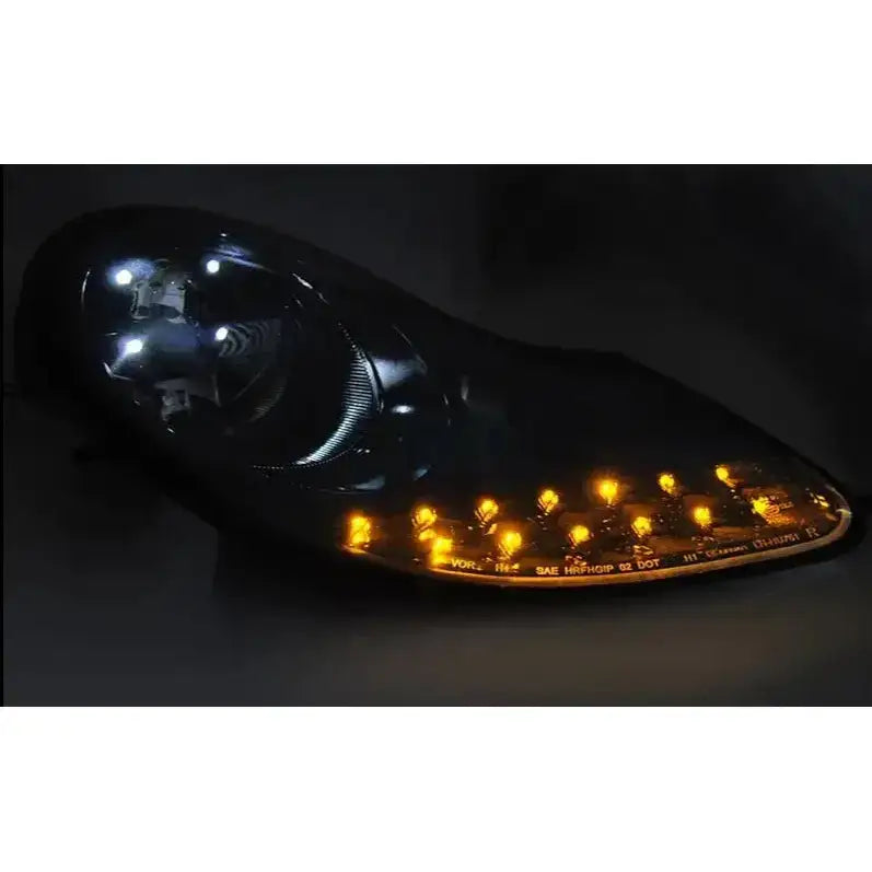 Hovedlykter Matt Black Porsche Boxster 96-04 med hvite og oransje LED-lys, svart hus og reflektorstruktur.