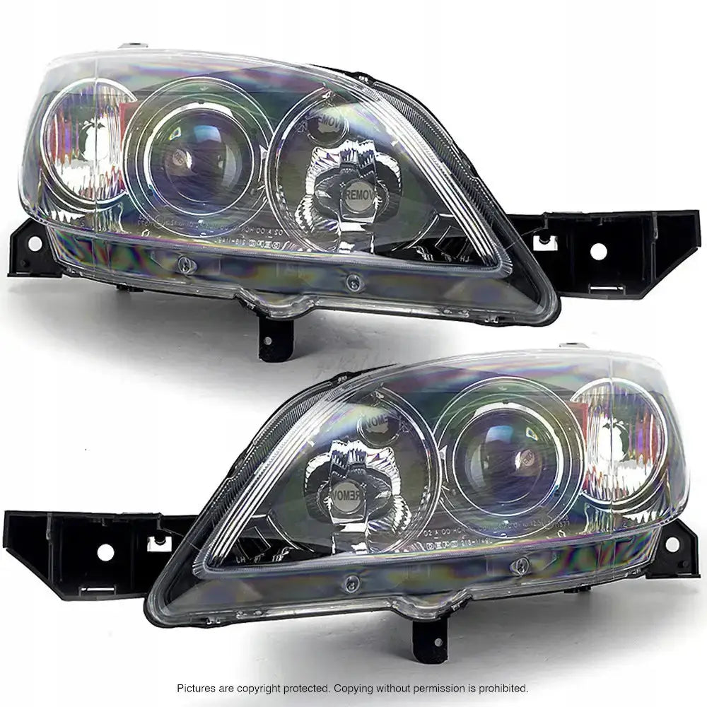 Frontlykter Mazda 3 03-06 Hatchback sett skrått forfra med klare glass og synlige reflektorer.
