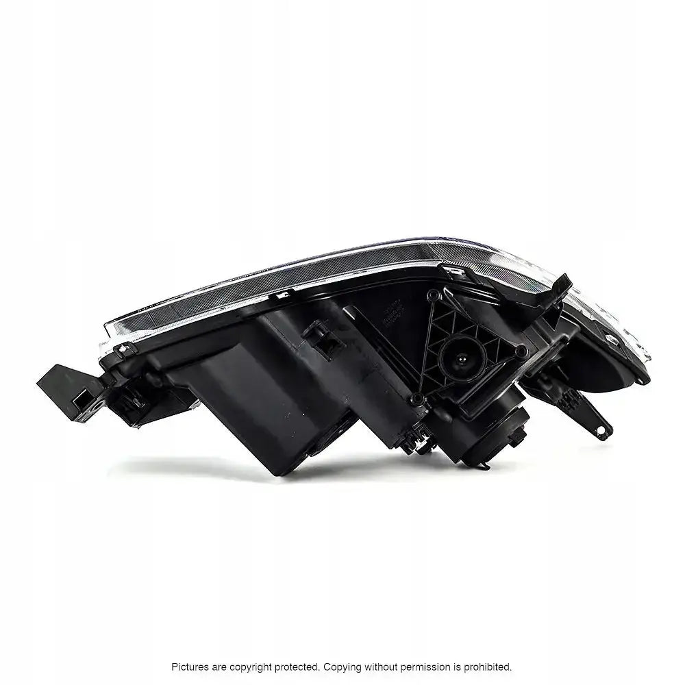 Frontlykter Mazda 3 03-09 sett fra siden med synlige monteringsfester og detaljer mot hvit bakgrunn.