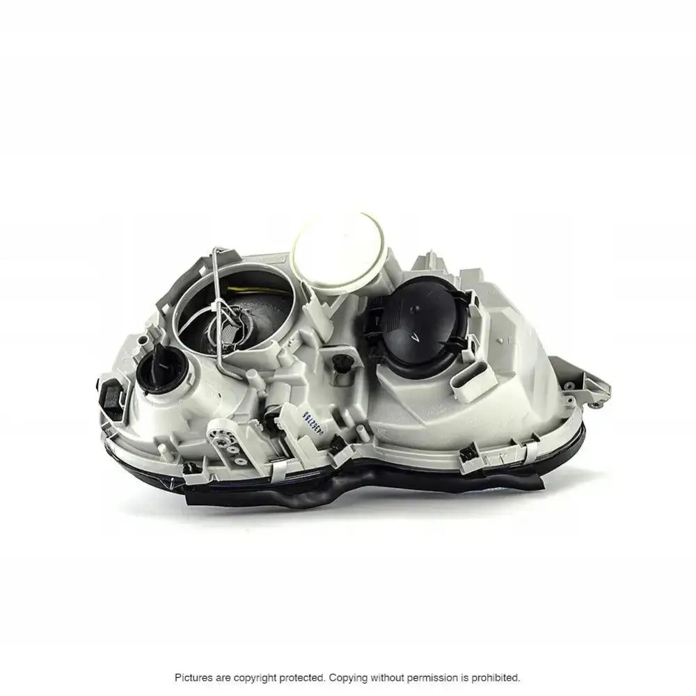 Hovedlys bakside av Mercedes C-Klasse W203 frontlykt med sorte deksler og tekniske detaljer.