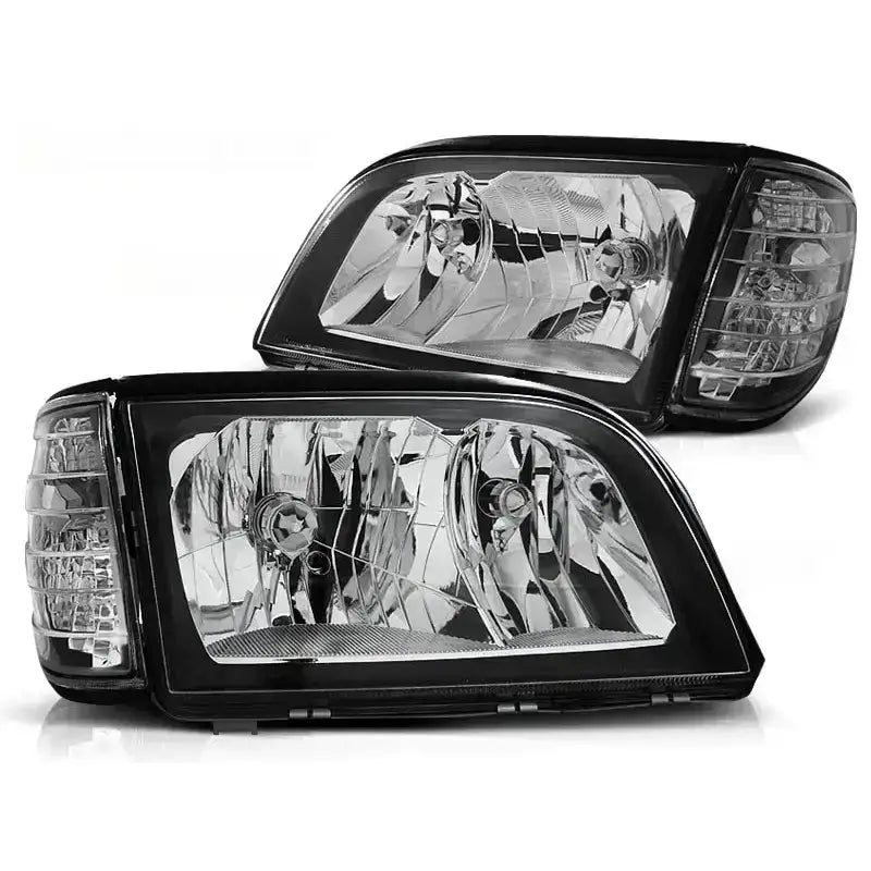 Frontlykter Mercedes W140 S-Klasse med sorte rammer og klart glass sett fra skrå vinkel.