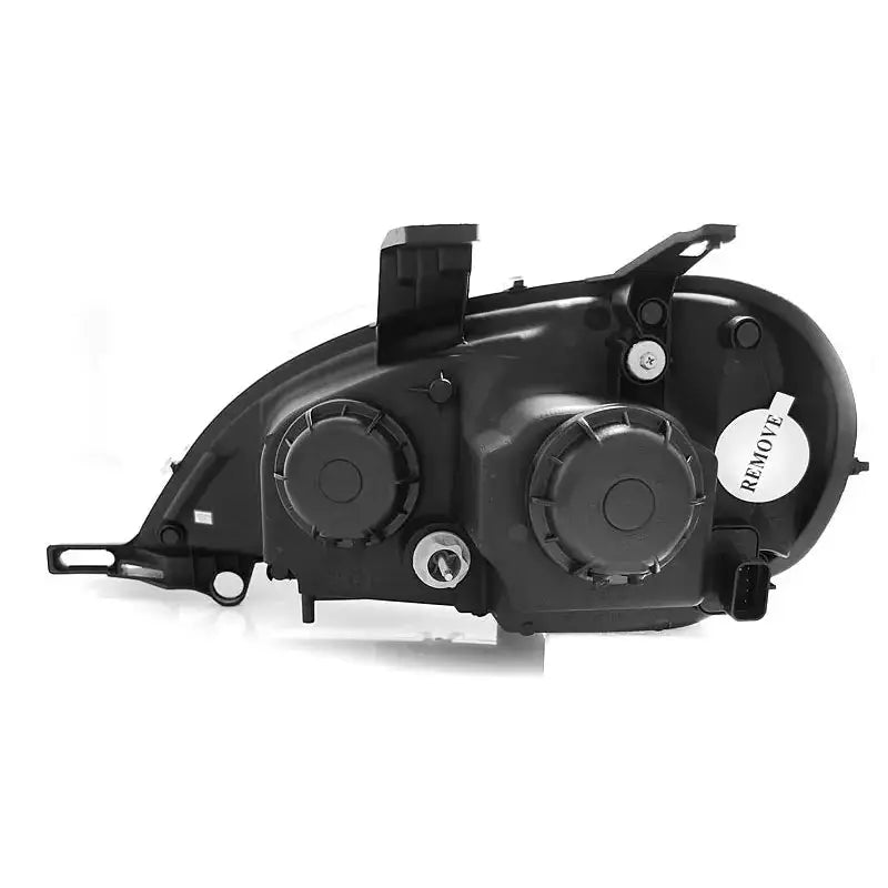 Hovedlykter Mercedes W163 ML bakside i sort plast med to runde deksler og hvit "REMOVE"-etikett.