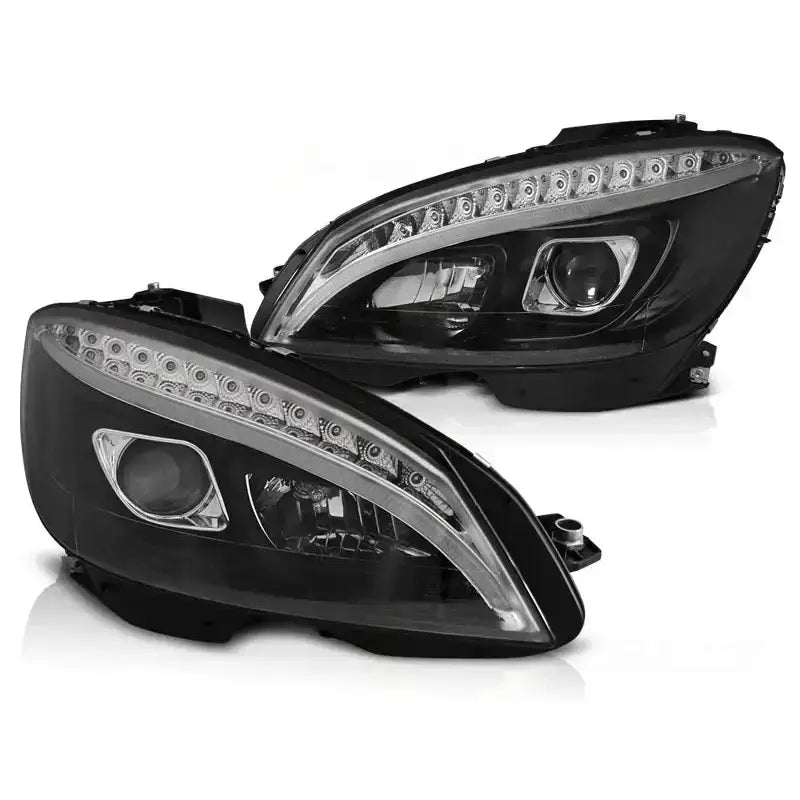 Hovedlykter Mercedes W204 07-10 i sort med klare linser og LED-lys, avbildet skrått forfra.