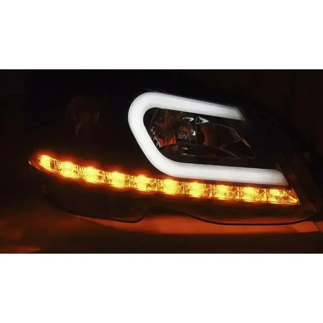 Hovedlys Mercedes W204 sort lykt med hvit LED-ramme og oransje lys, sett fra skrå vinkel.