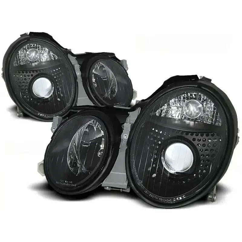 Frontlykter Mercedes W208 CLK sorte ovale lykter med klare reflektorer, sett fra skrå vinkel.