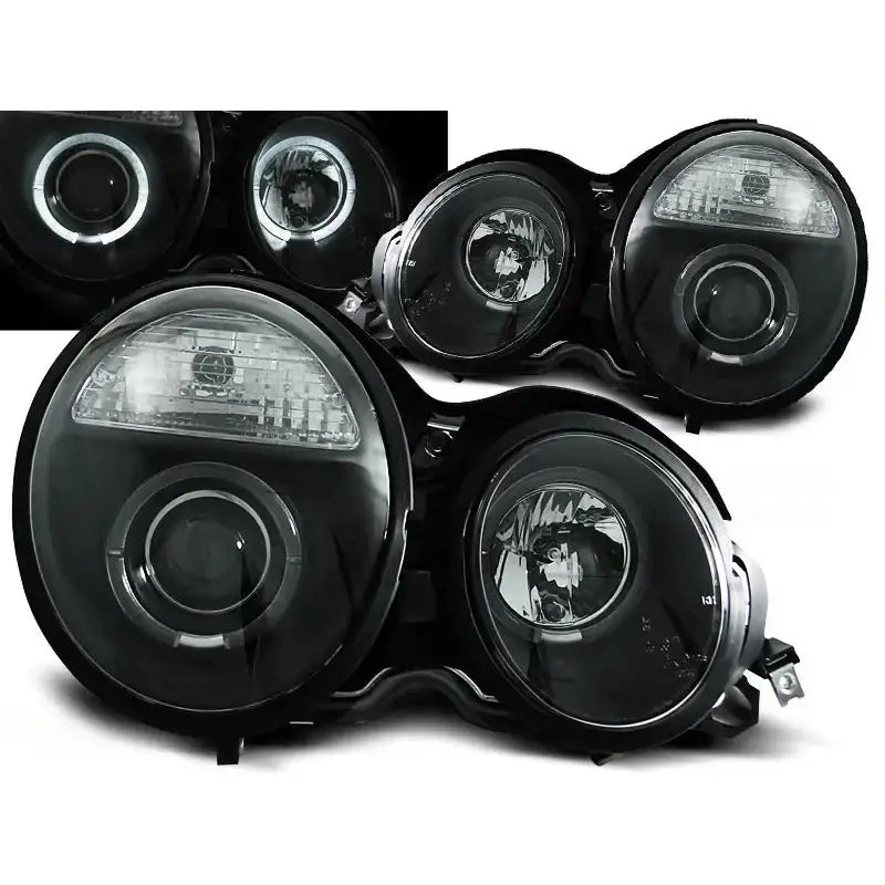 Frontlykter Mercedes W210 E-Klasse Angel Eyes Black med klare glass og lyssirkler, sett skrått forfra.