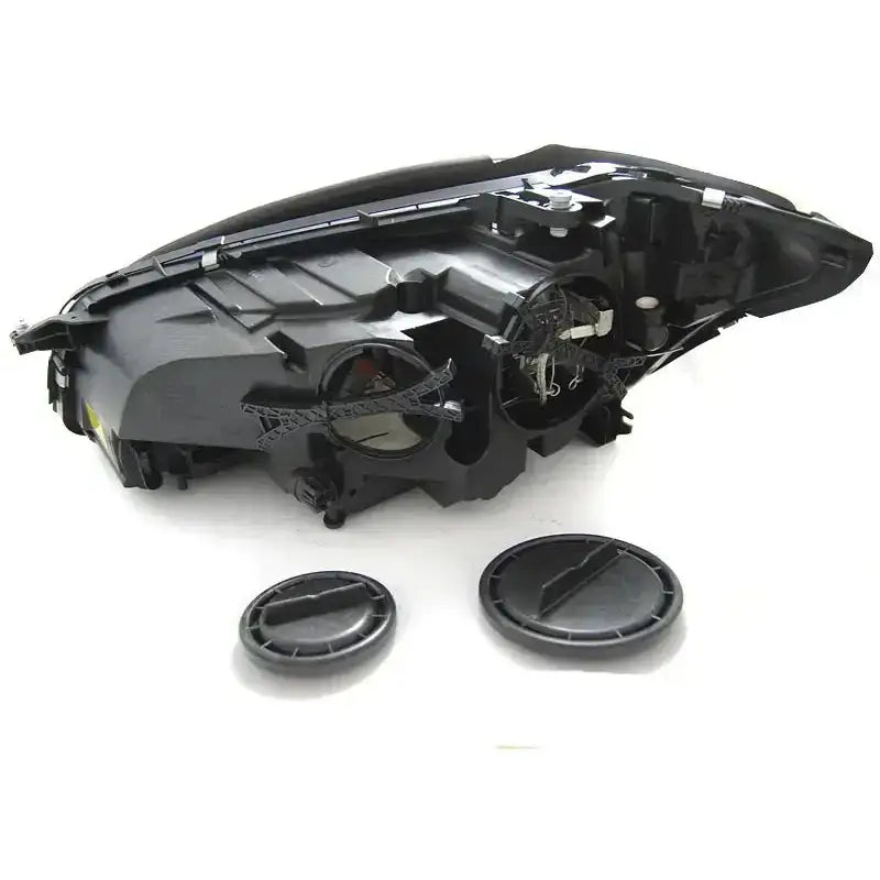 Hovedlys Mercedes W221 bakside med åpne deksler og synlige ledninger på hvit bakgrunn.