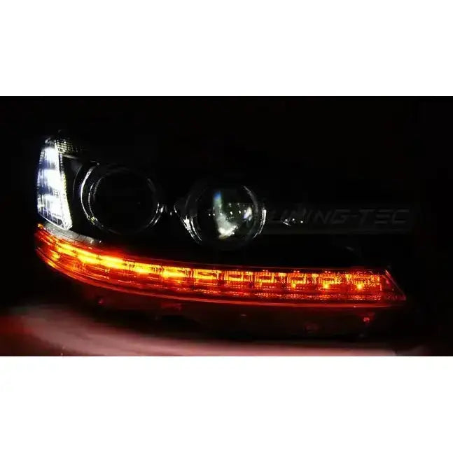 Hovedlys Mercedes W221 Daylight HID Black med oransje LED-list, sett fra skrå vinkel mot venstre.
