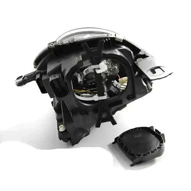 Hovedlys Mini Cooper 06-14 black vist fra skrå bakside med åpent deksel og synlige elektriske komponenter.