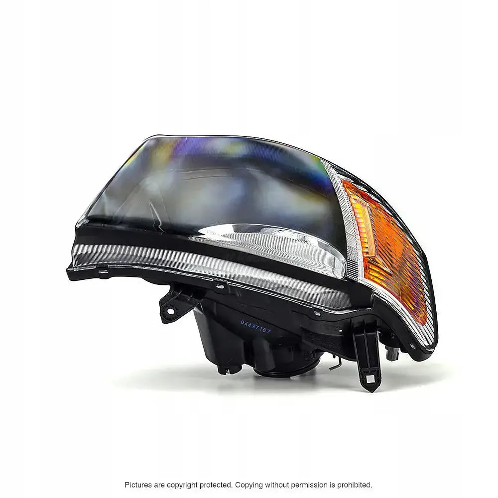 Frontlykter Mitsubishi L200 05-10 sett fra skrå vinkel med klare og oransje felter mot hvit bakgrunn.