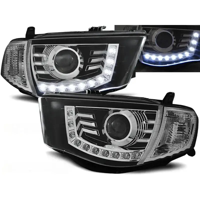 Frontlykter Mitsubishi L200 06-10 Daylight Black med sorte og kromdetaljer, LED-bue nederst.