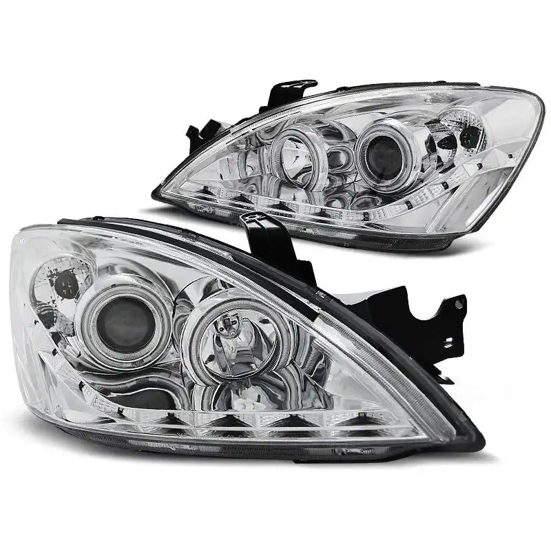 Hovedlykter Mitsubishi Lancer 7 04-07 chrome, to klare lykter med sølvdetaljer sett skrått forfra.