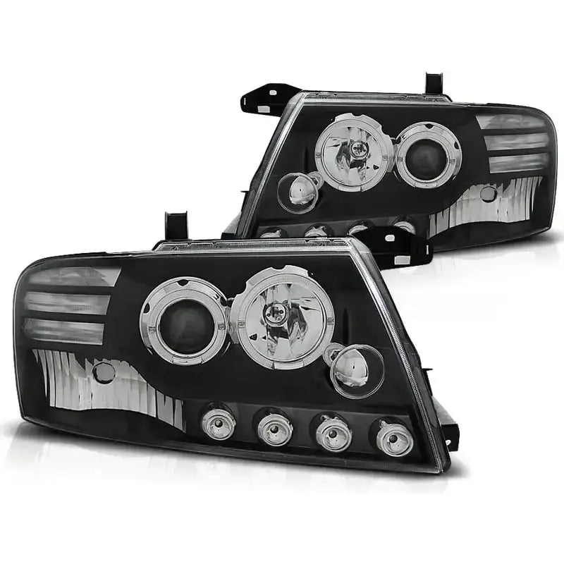 Hovedlykter Mitsubishi Pajero V60 Angel Eyes Black med sort bakgrunn, kromdetaljer og LED-innsatser.