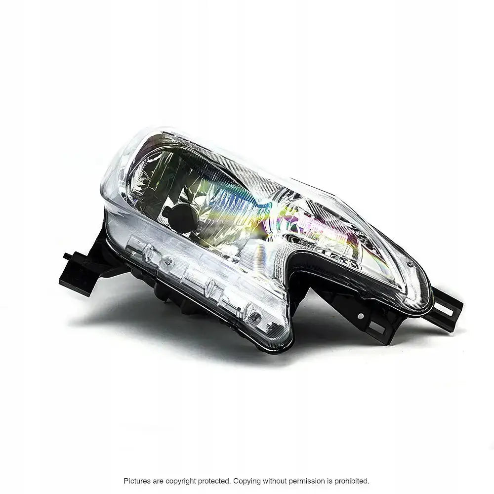 Hovedlykter Nissan Note 13-16 H4 sett fra skrå vinkel med reflekterende detaljer og festebraketter.