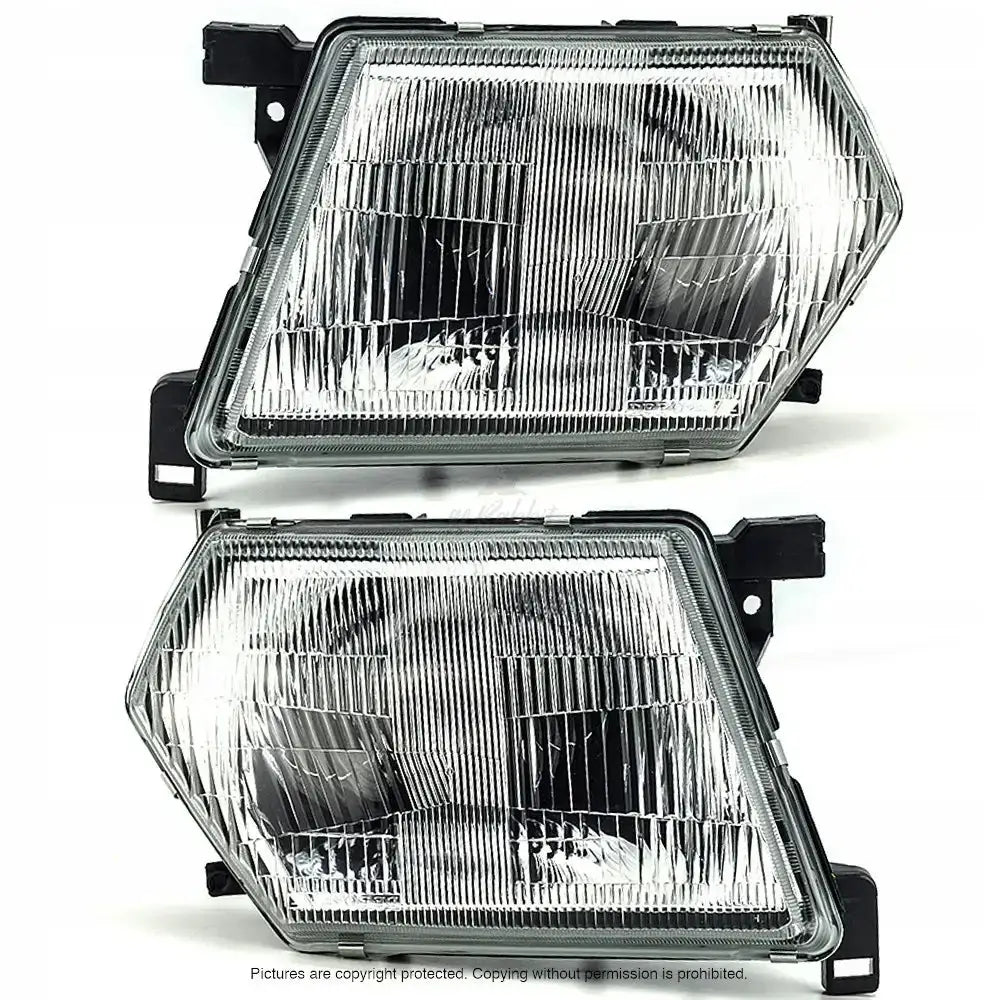 Frontlykter Nissan Patrol Y61 97-03 med klart rillemønstret glass og sorte braketter, sett forfra.