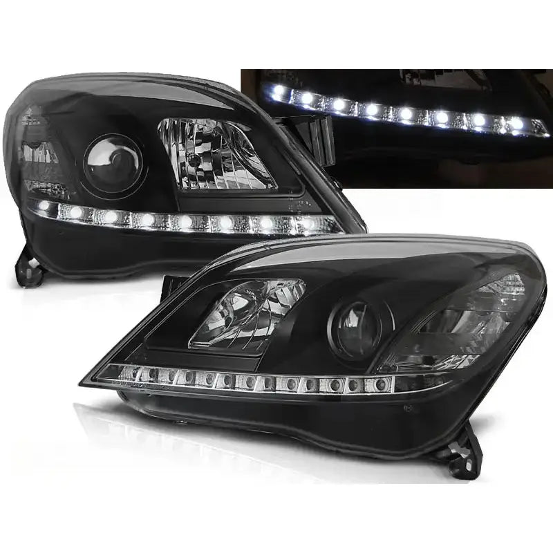 Frontlykter Opel Astra H 03.04-09 i svart med klare linser og LED-lysrekke, sett fra skrå vinkel.