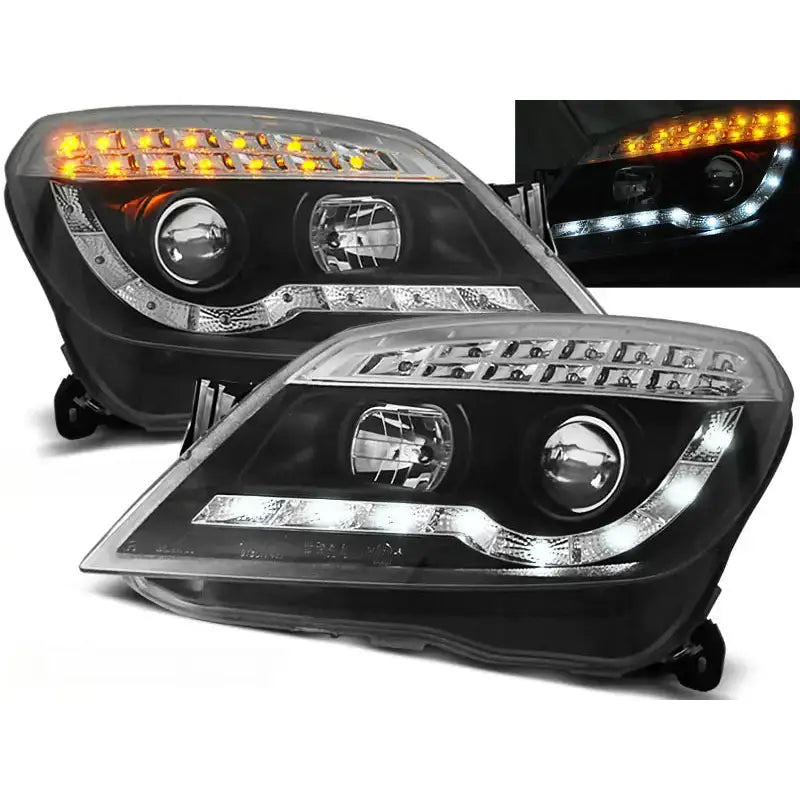 Frontlykter Opel Astra H 03.04-10 i svart med LED-striper og oransje blinklys, tent i mørket.