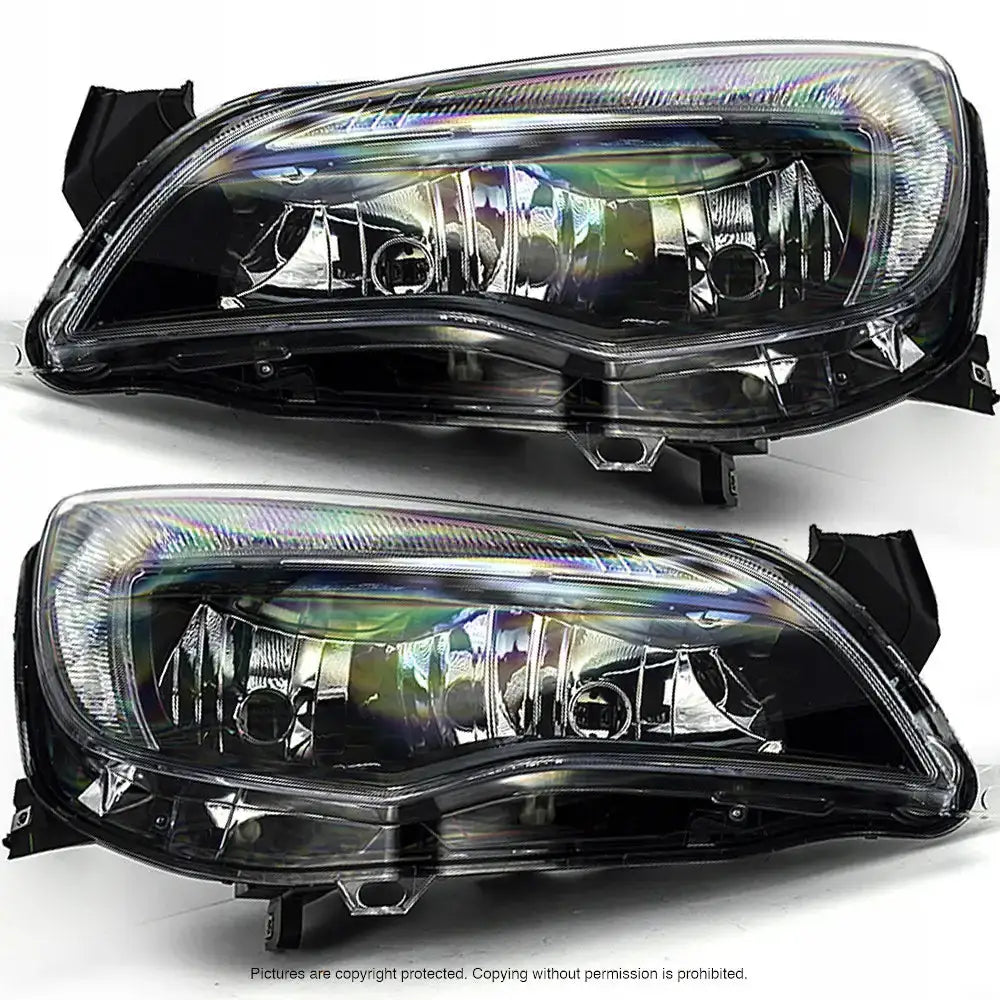 Frontlykter Opel Astra J H7/H7 i klart glass og sort plast, sett fra skrå vinkel på hvit bakgrunn.