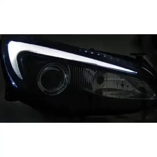Hovedlykter Opel Astra J Tube Light Black med hvitt LED-lys og runde reflektorer, skrå forside.