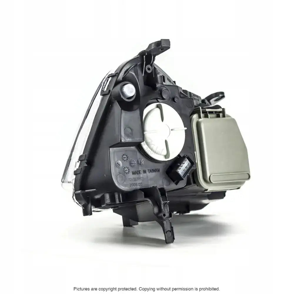 Headlights Opel Corsa C 03-10 vist fra skrå bakside med hvitt deksel og grått rektangulært lokk.