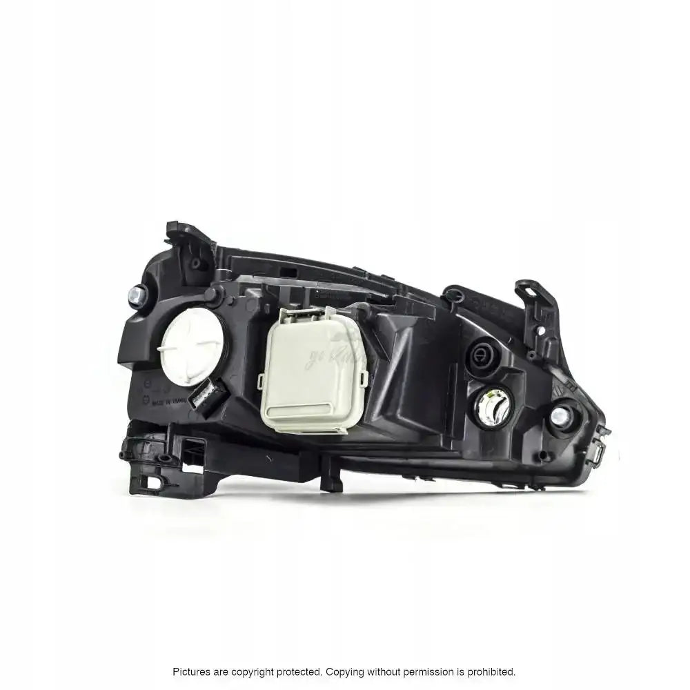 Hovedlykter Opel Corsa C vist fra baksiden med svarte plastdetaljer og runde tilkoblingspunkter.