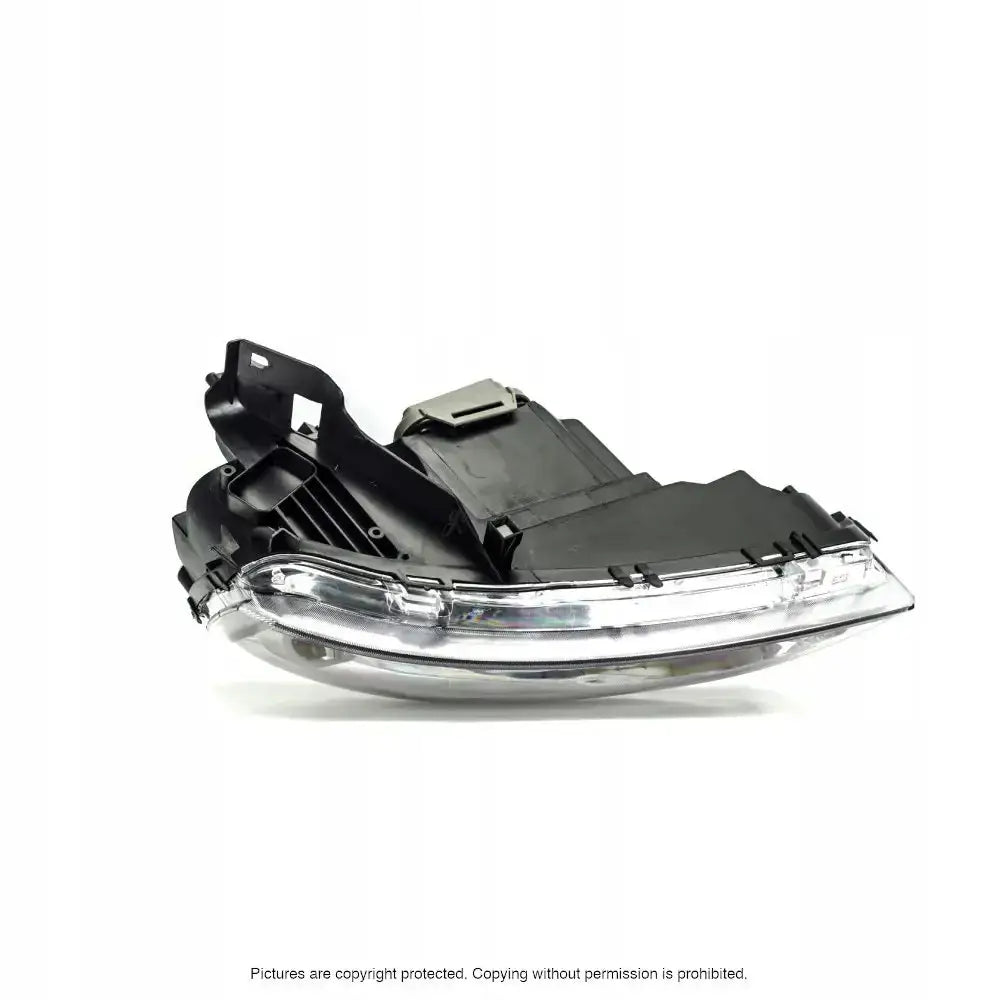 Hovedlys Opel Corsa C 03-10 i sort og sølv plast med detaljerte konturer, avbildet fra skrå vinkel.