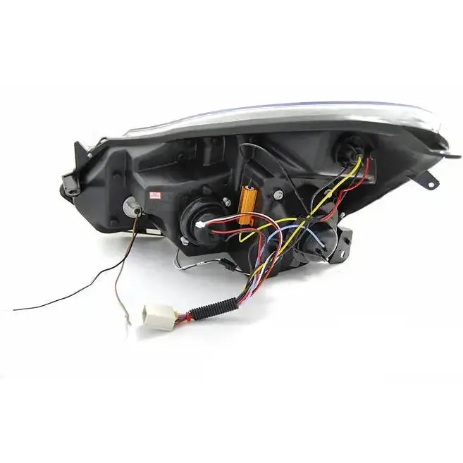 Hovedlys Opel Corsa D bakside med synlige ledninger og hvit kontakt, svart plastkonstruksjon.