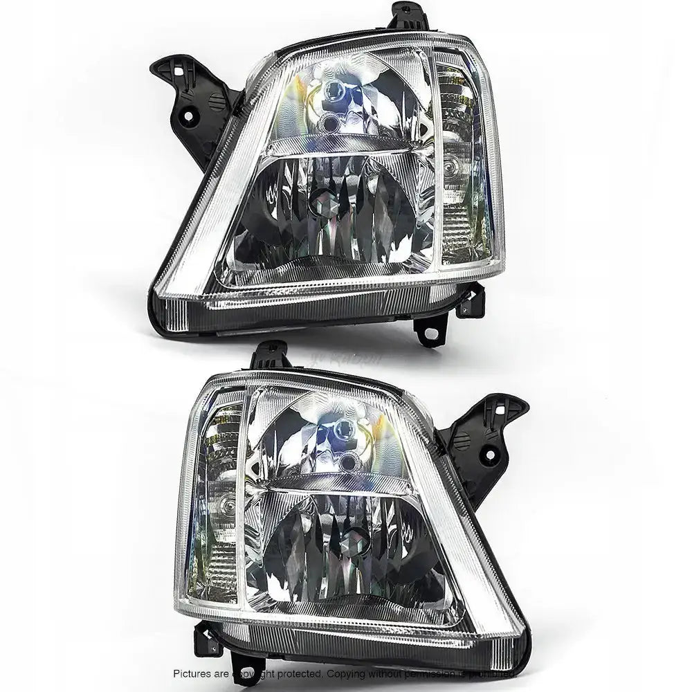 Frontlykter Opel Meriva A 03-10 sett forfra med klare linser og sorte monteringsfester mot hvit bakgrunn.