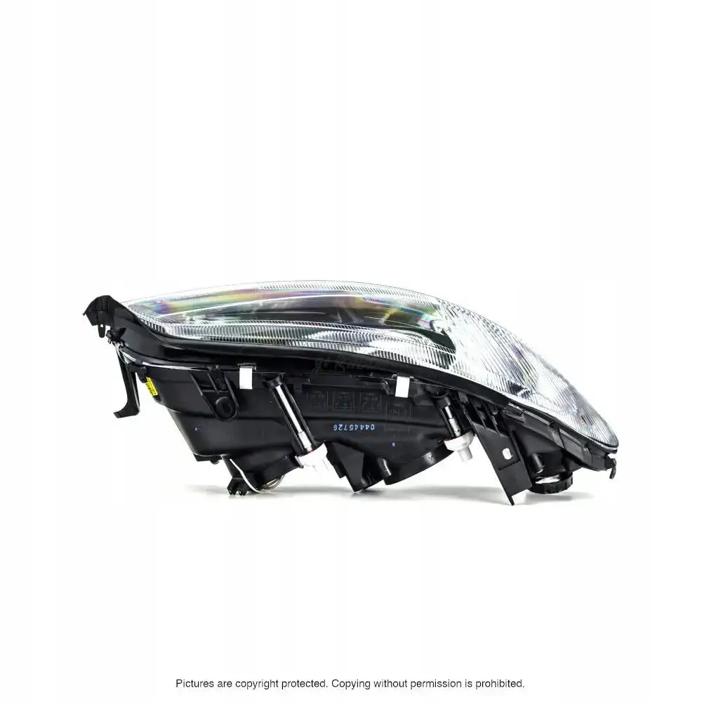 Frontlykter Opel Omega B 99-03 H7 vist fra siden med klart glass og sorte detaljer på hvit bakgrunn.