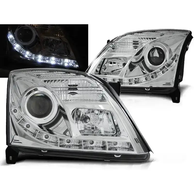 Frontlykter Opel Vectra C 04.02-08.05 i krom med LED-striper, vist fra skrå vinkel, tent i mørke.