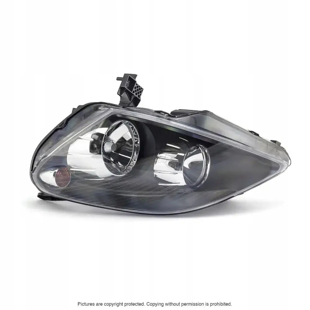 Hovedlykter Opel Zafira B 05-08 med klart glass og sorte detaljer sett fra skrå vinkel.