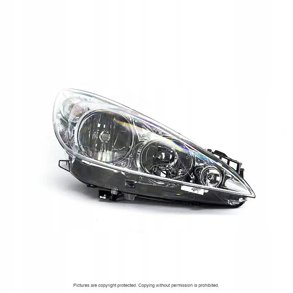 Hovedlykter Peugeot 308 07-11 i klart glass med svart plast, sett fra skrå side mot hvit bakgrunn.