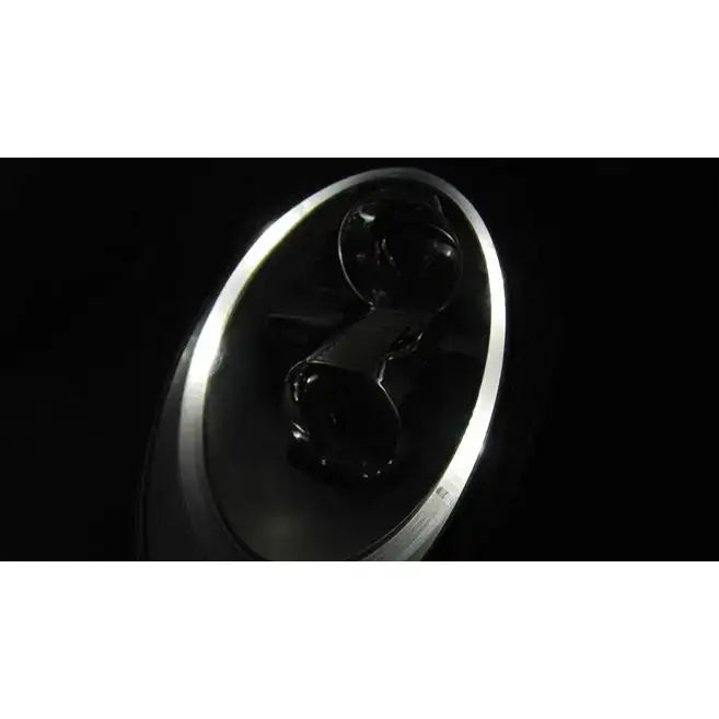 Hovedlys Porsche 911 997 Black Xenon med rund metalloverflate og sterk lysrefleksjon på mørk bakgrunn.