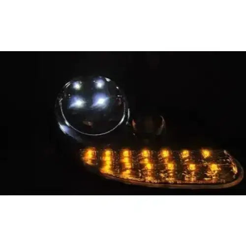 Hovedlys Porsche Boxster 96-04 Daylight Chrome med runde LED og oransje lysdioder i mørket.