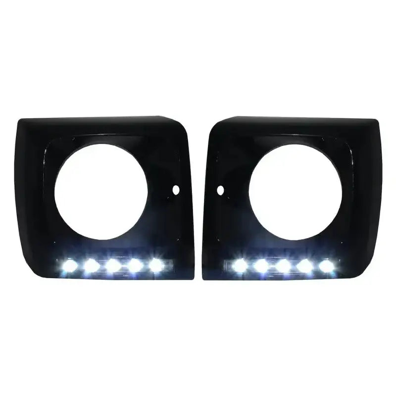 Frontlykter ramme til Mercedes Geländewagen W463 med svarte deksler og LED DRL, sett forfra mot hvit bakgrunn.