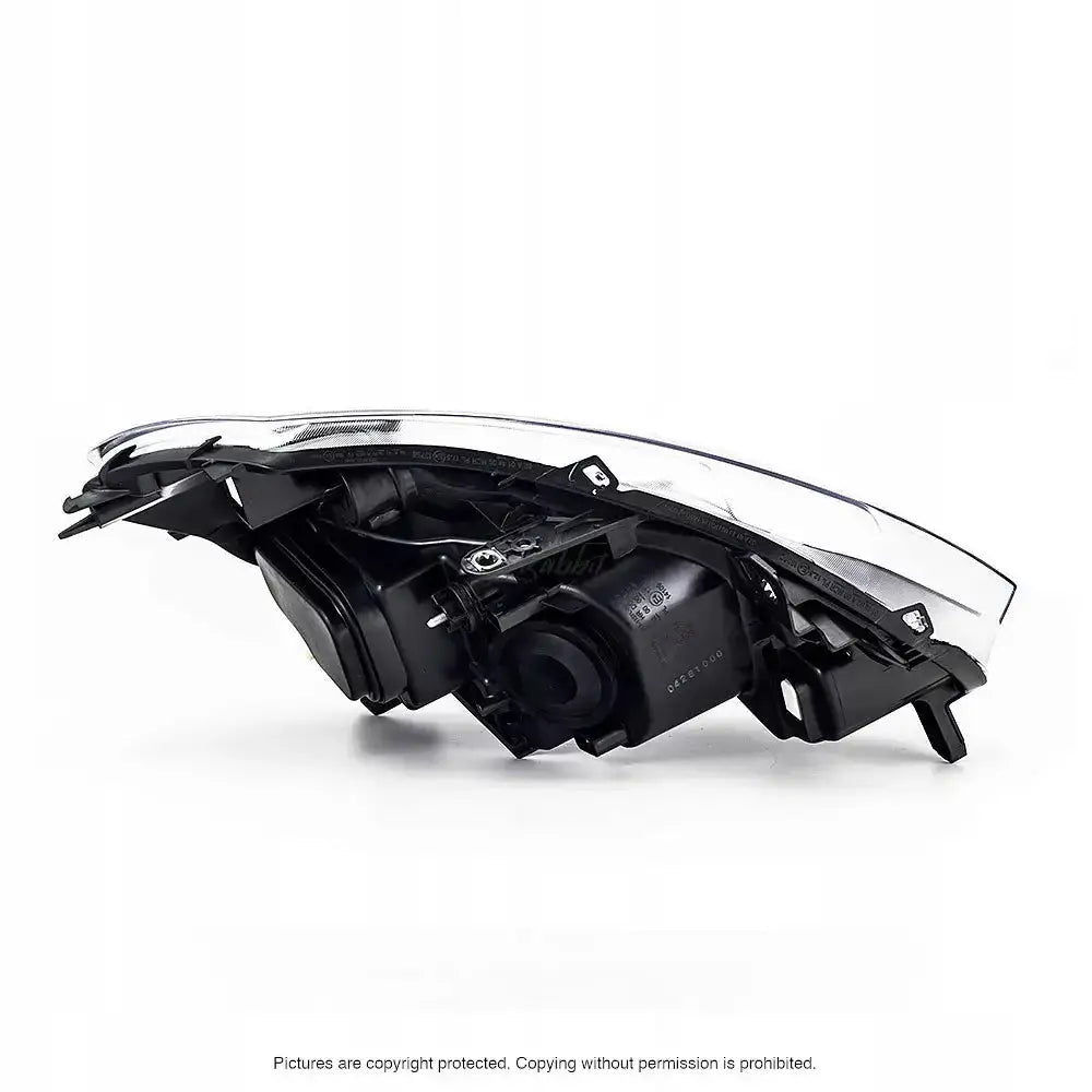 Headlamp Renault Clio 3 frontlykt sett fra siden med sort hus og klar linse på hvit bakgrunn.