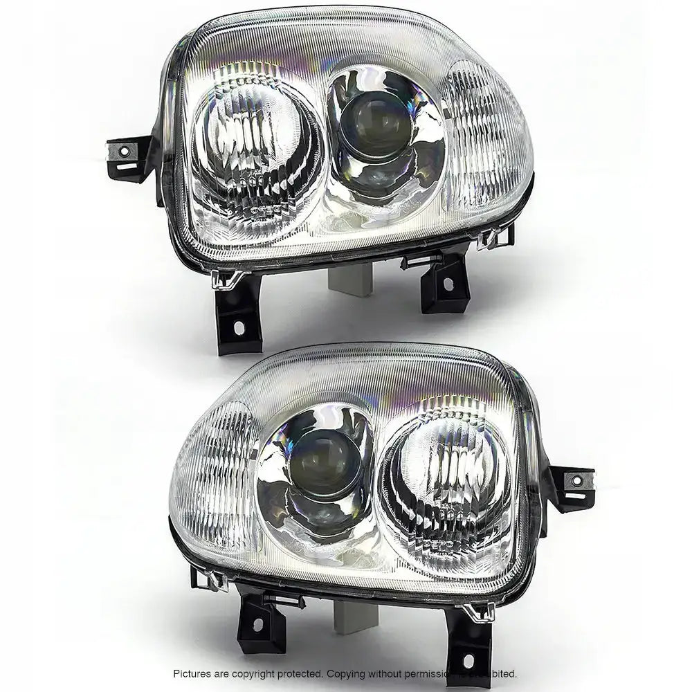 Frontlykter Renault Clio II 98-01 med klart glass og svart plast, sett skrått forfra mot hvit bakgrunn.