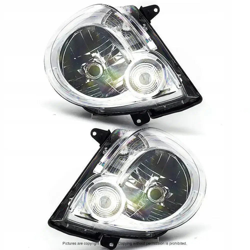 Frontlykter Renault Kangoo 08-13 H4 sett skrått ovenfra med klart glass og sort innramming på hvit bakgrunn.