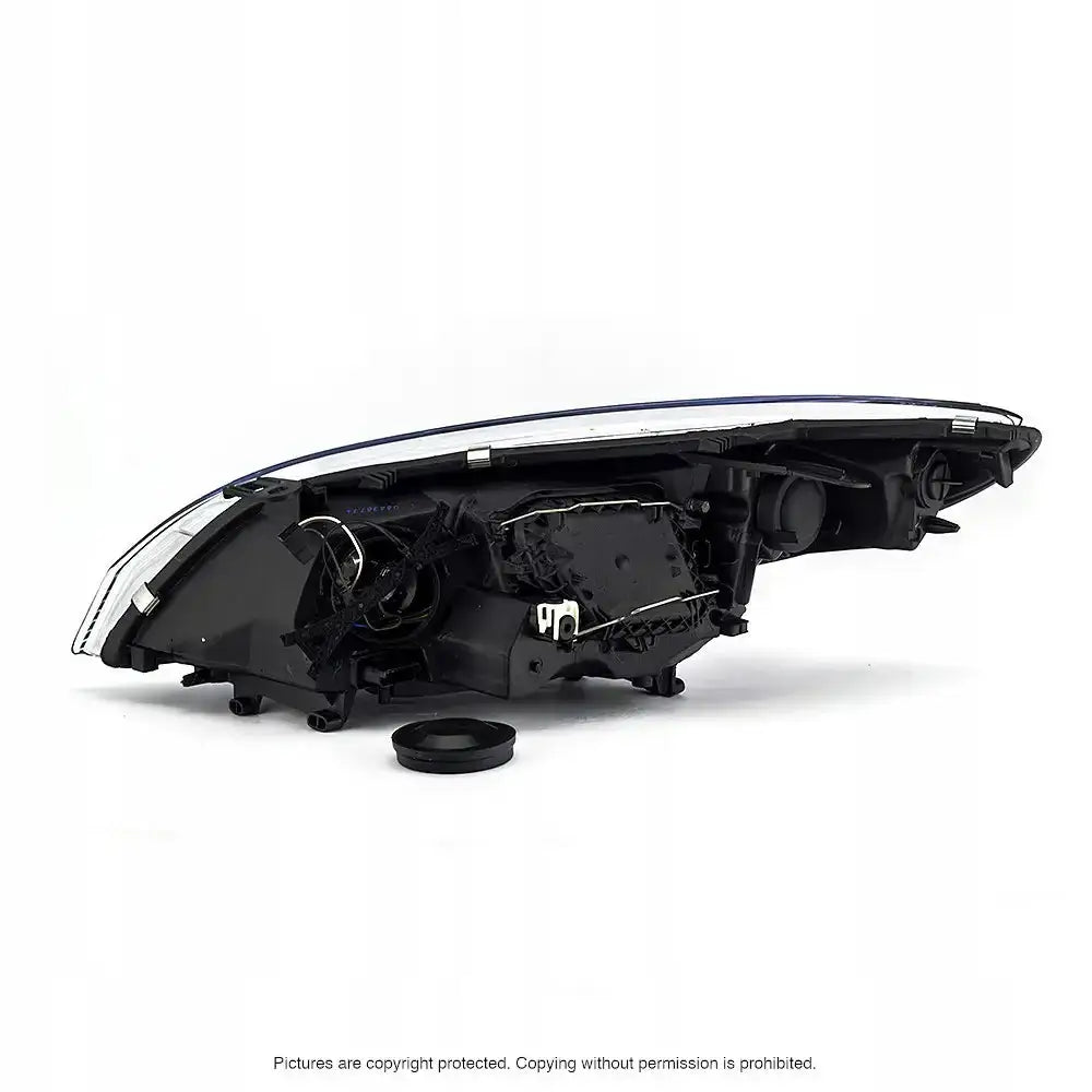 Headlamp Renault Megane 3 bakside med synlige elektroniske komponenter og løse deler mot hvit bakgrunn.