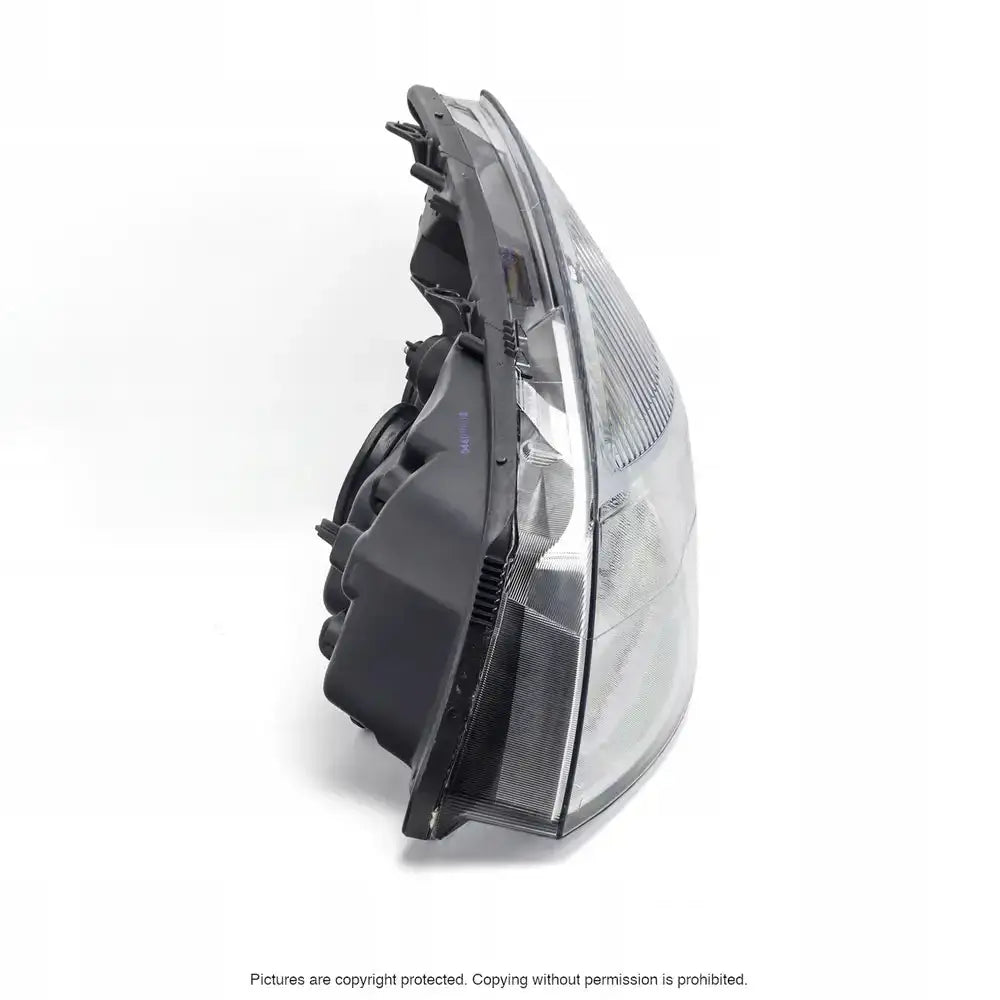 Hovedlykter Renault Scenic 03-09 i klar og sort plast, vist fra siden med synlig reflektordetalj.