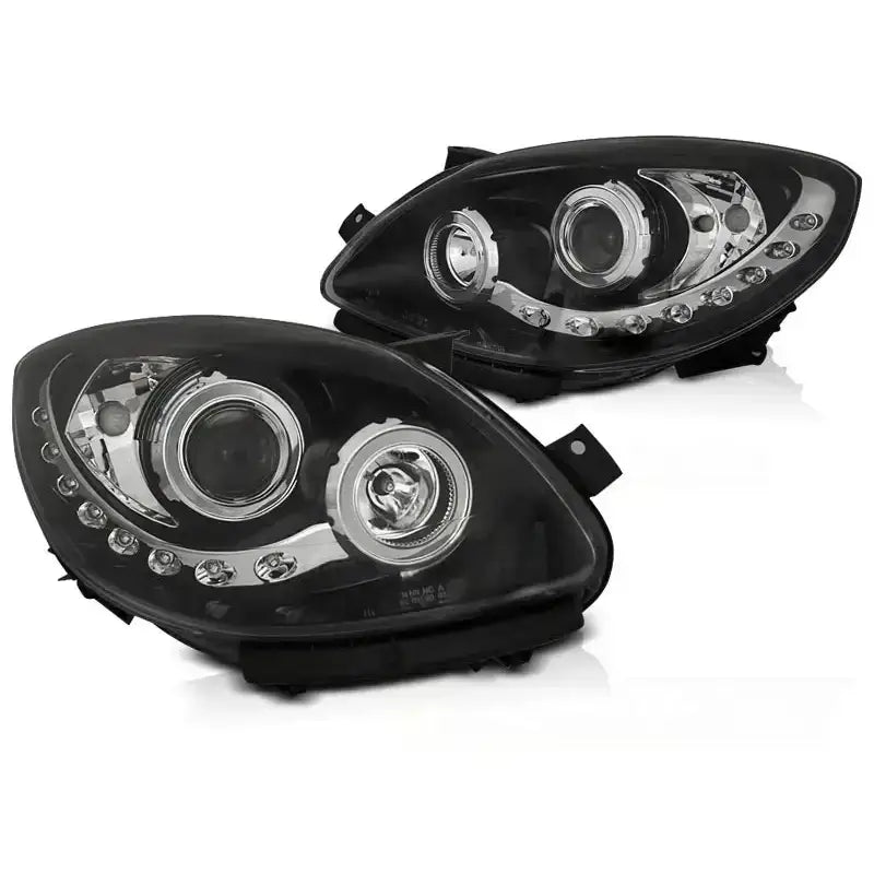 Frontlykter Renault Twingo 07-11 Daylight Black med sort ramme, klare linser og LED-lys, skrå vinkel.