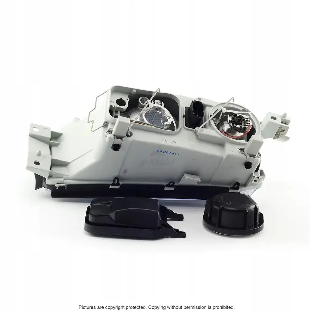 Hovedlys Skoda Octavia 1 bakside med åpne pærefester, elektriske kontakter og to svarte deksler.